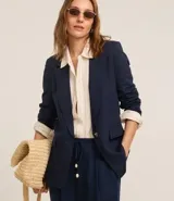 Blazer celeste de viscosa y lino, con cuello inglés, cierre de un botón y solapas.