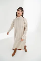 Vestido midi de tejido de punto color crema, con cuello alto, mangas largas y corte recto con aberturas laterales.
