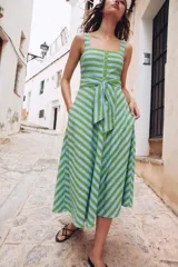 Vestido midi de tirantes anchos y escote cuadrado con rayas horizontales verdes y celestes en la parte superior y verticales en la falda. Cuenta con botones frontales dorados y un cinturón de la misma tela para anudar en la cintura.