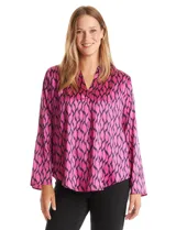 Blusa de satén color fucsia con estampado abstracto en negro, escote en V y mangas largas con presilla y botón para regular el largo.