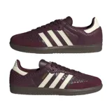 Championes Adidas Samba OG de color bordó con textura símil piel de serpiente y detalles en blanco marfil. Cuentan con las clásicas tres tiras laterales, inscripción 'SAMBA' en letras doradas, refuerzo de gamuza en la puntera y suela de goma marrón.