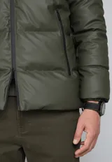 Campera puffer verde militar con capucha negra de cuero sintético, cierre frontal con cremallera y bolsillos laterales con cierre.