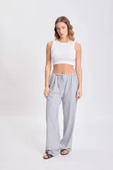 Pantalón de pijama de corte recto, con cintura elástica y cordón ajustable, con estampado de rayas verticales azules y blancas.