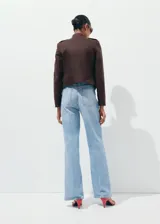 Pantalón de jean de tiro medio y diseño wide leg con bolsillos de solapa delanteros, trabillas para cinto y cierre con gancho y cremallera.