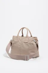 Bolso de mano de Bimba y Lola confeccionado en nylon color beige, con estructura blanda, doble asa superior y correa ajustable extraíble. Presenta dos bolsillos frontales con cierre, logo metálico frontal y cierre principal de cremallera.