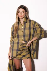Camisa oversize a rayas celestes y blancas, con cuello camisero, manga larga y hilera de botones dorados metálicos.