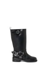 Borcegos de caña alta (30 cm) color negro, confeccionados en ecocuero, con suela gruesa y bajo relieve. Presentan una correa con hebilla metálica plateada alrededor del tobillo y una correa ajustable con hebilla en la caña superior.