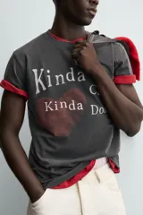 Camiseta de manga corta y cuello redondo, color negro con efecto lavado. Presenta un estampado frontal con un corazón rojo y texto en blanco que dice "Kinda Care Kinda Don't".