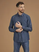 Camisa de manga larga azul con pequeños lunares blancos, cuello clásico y bolsillo en el pecho.