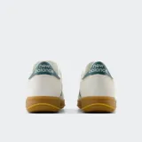 Championes New Balance CT500 color crema con detalles en azul y suela marrón de goma.