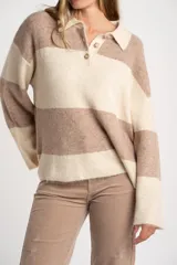 Sweater de punto con cuello polo y cierre frontal de tres botones. Presenta un diseño de corte oversize, mangas largas y textura acanalada.