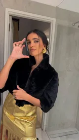 Campera corta de piel sintética negra con cuello solapa y cierre frontal, de diseño estructurado y elegante.
