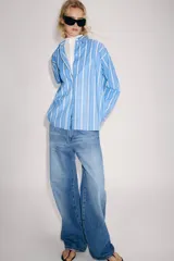 Camisa ZW Collection de algodón, con diseño a rayas verticales celestes y blancas, cuello solapa, manga larga y bolsillo de parche en el pecho con cierre frontal de botones ocultos.