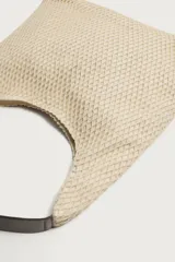 Bolso tipo shopper de tejido de algodón color beige, con diseño de red exterior y compartimento principal con cierre de imán. Cuenta con asa de mano oscura a contraste y bolsillos interiores.