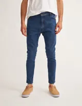 Jean de denim azul oscuro, corte skinny, tiro medio y cinco bolsillos.