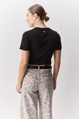 Remera blanca de manga corta y cuello redondo, con calce ajustado al cuerpo y diseño liso y minimalista.