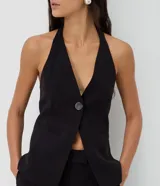 Chaleco sastrero halter negro con escote en V profundo, un botón central y bolsillos ribeteados simulados.