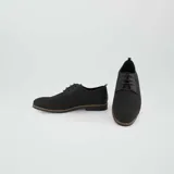 Zapatos de vestir negros con cordones y suela marrón.