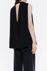 Blusa negra de viscosa con corte línea A, escote en pico con tira en el cuello con botón, manga sisa y minipliegues en hombros para dar volumen.