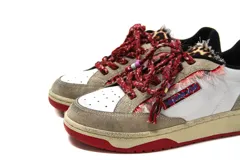 Zapatillas casual Arizona Love con base color beige, puntera blanca y detalles de tela estampada con motivos de leopardo y flores. Cordones gruesos rojos con cuentas de colores.