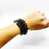 Pulsera semirrígida de cristales negros montada sobre hilo metálico plateado.
