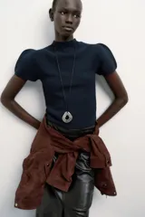 Jersey de punto liso color azul marino, con cuello redondo y mangas cortas abullonadas.