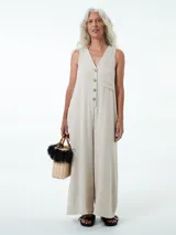 Mono largo color beige con botones frontales, bolsillos laterales y confeccionado en viscosa, lino y metal.
