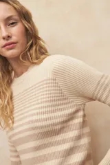 Sweater a rayas horizontales rojas y blancas, de mangas largas acampanadas y cuello redondo.