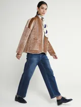 Saco marrón de terciopelo acanalado, con cuello mao y bolsillos frontales.