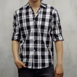 Camisa de manga larga a cuadros blancos y negros, de algodón fino.