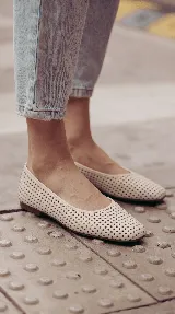 Chatita de cuero color off-white, con diseño calado en toda su superficie y punta redondeada.