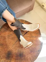 Botas texanas de cuero combinadas en color crudo y marrón, con caña media, punta cuadrada y diseño bordado en el empeine.