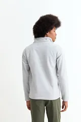 Buzo de polar color bordó, con cuello alto y cierre frontal parcial, de manga larga y diseño funcional con bolsillos laterales.