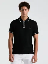 Polo negra de piqué con vivos blancos en cuello y mangas, calce slim fit y logo bordado en el pecho.