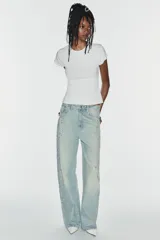 Jeans baggy de tiro medio, pierna ancha y diseño de cinco bolsillos, confeccionados en denim celeste con aplicaciones de brillos en los laterales.
