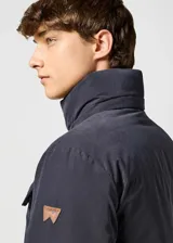 Campera de hombre color negro, con cuello alto, cierre frontal con cremallera y botones a presión, múltiples bolsillos y puños con botón.