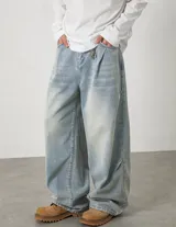 Jean baggy de tiro alto y lavado claro, con diseño amplio, pinzas y efecto desgastado en los muslos.