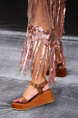 Sandalia de plataforma color caramelo con tira ancha en el empeine y tira fina ajustable en el tobillo con hebilla dorada.