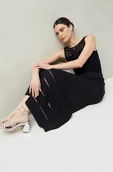 Falda larga negra de punto con silueta al cuerpo y leve evasé. Presenta transparencias lineales en el ruedo.