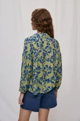 Camisa de calce amplio confeccionada en viscosa fluida con estampado animal print tipo cebra en blanco y negro. Presenta cuello camisero, escote en V y mangas largas con puños elastizados, además de frunces en el canesú que aportan volumen.