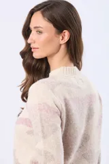 Buzo de tejido de punto con diseño jacquard estampado en tonos rosados y beige, de corte holgado, cuello redondo y mangas largas con puños acanalados.