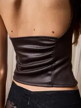 Top marrón de cuero sintético con un solo hombro y corte ajustado.