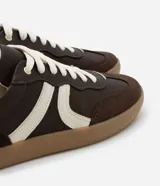 Championes de estilo retro inspirados en calzado de fútbol, confeccionados en poliuretano color verde menta con detalles laterales en rosado. Presentan suela plana de goma color caramelo y cierre mediante cordones al tono.