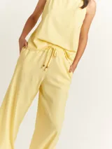 Pantalón de lino color lila, tiro alto, corte palazzo con elástico en la pretina, bolsillos laterales y dobladillo invisible.