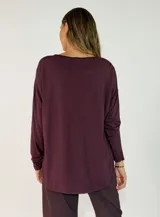 Blusa de satén color bordó, con escote en V, mangas largas y corte holgado.