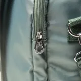 Bolso matero de diseño acolchado en color verde, con cierre doble, asas fijas y correa regulable extraíble. Cuenta con logotipo de la marca en el frente y múltiples compartimentos internos y externos.