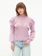 Buzo de tejido de punto calado en color lila, con cuello alto, mangas largas con puños ajustados y detalle de volados en los hombros.