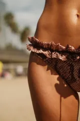 Bombacha de bikini con estampado de piel de serpiente en tonos marrones y volados en la cintura.