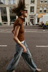 Top de tejido de punto color marrón óxido, manga corta y cuello mao con cierre frontal de botones.