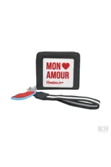 Billetera tipo monedero de color negro con cierre de cremallera. Presenta un parche frontal blanco con texto en rojo que dice "MON ❤️ AMOUR" y debajo "Oreiro Love". Incluye un llavero desmontable con forma de labios rojos y una correa de mano negra con franjas blancas.